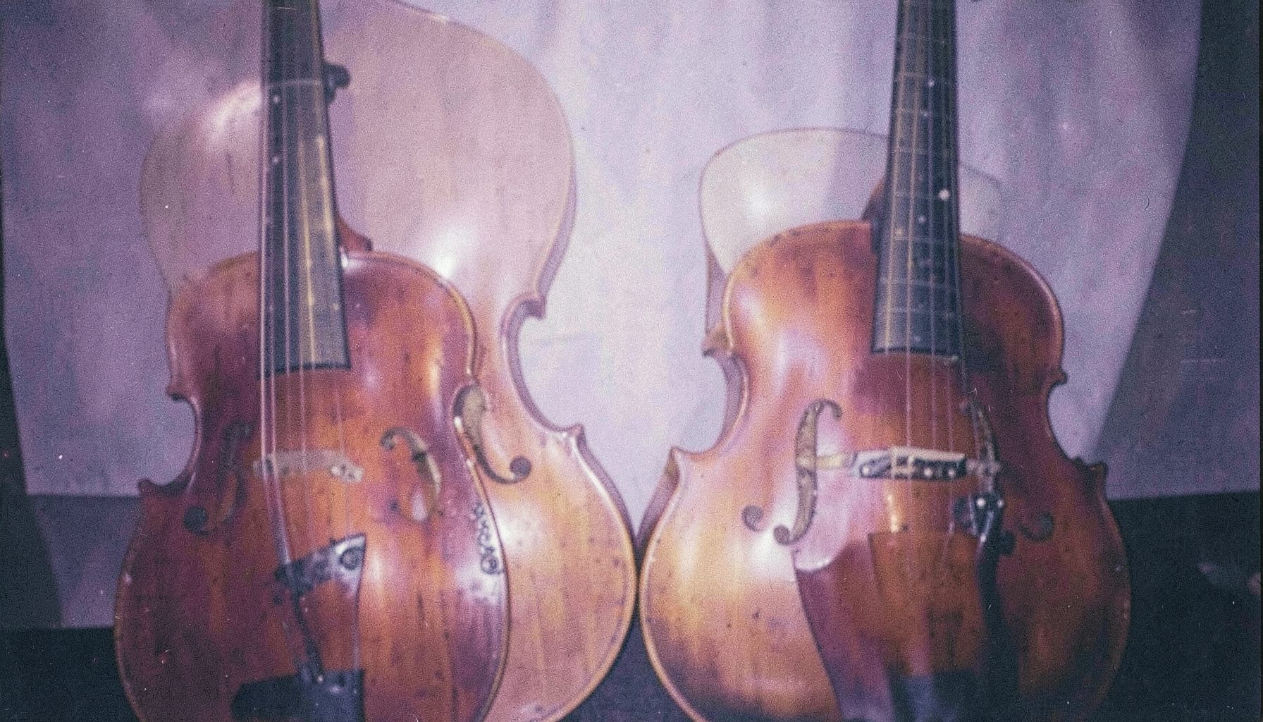 Sıcak amber ve lacivert tonlarında, yan yana dizilmiş ney ve def gibi geleneksel enstrümanlar, yumuşak odaklı analog fotoğraf.